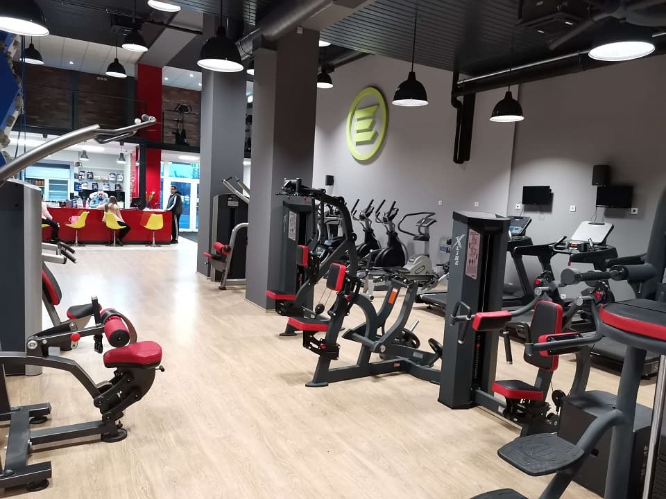 Piros recepciós pult a gépterem végében, mellette a bejárati rész