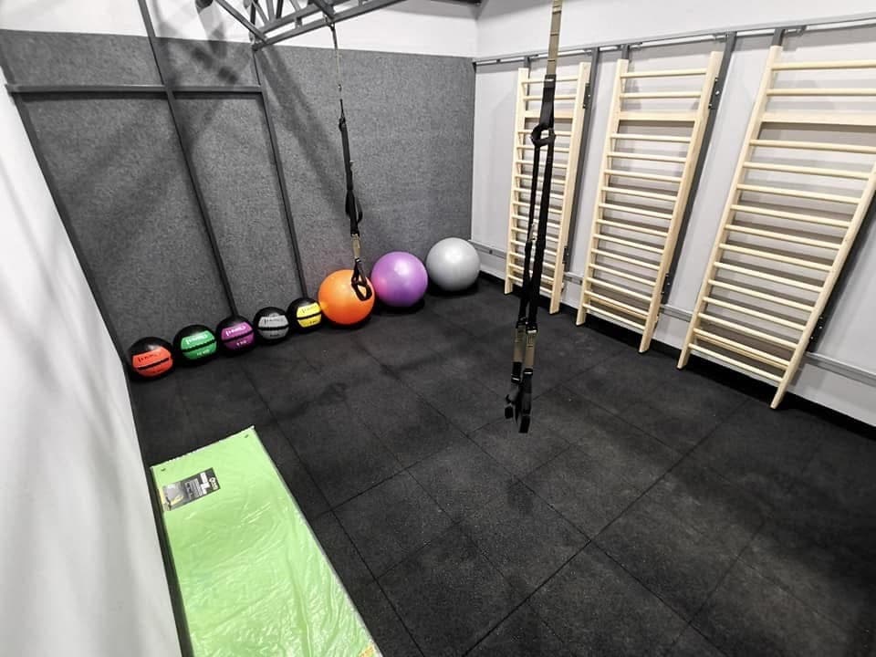Funkcionális edzőszoba TRX-hevederekkel, bordásfallal, medicinlabdákkal és fitballokkal